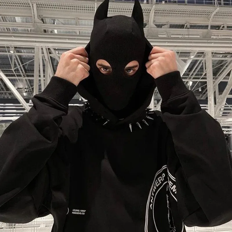 Modelo vestindo a máscara de demônio com chifres em look streetwear