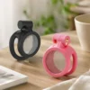 Cintos de castidade masculino micro preto e rosa lado a lado sobre mesa de madeira