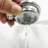Água passando livremente pela tela metálica do cinto de castidade masculino plano na limpeza