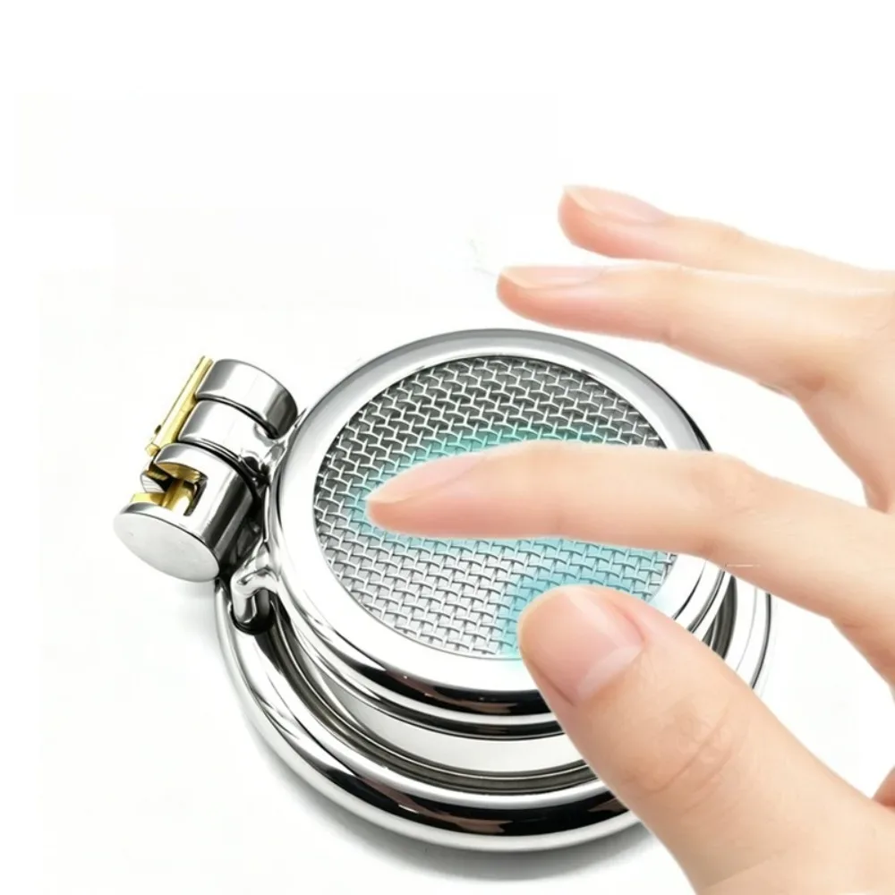 Dedo tocando a tela metálica vazada na frente do cinto de castidade masculino plano