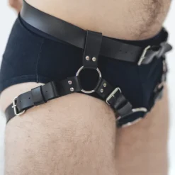Close da argola O-ring de metal do harness de strapon, entre as tiras rebitadas e as fivelas de ajuste