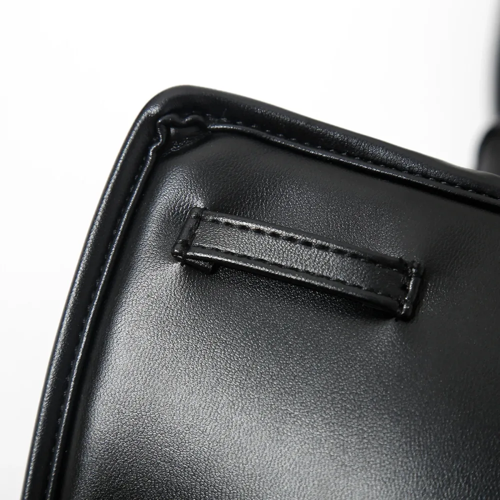 Detalhe do passante costurado na capa acolchoada, por onde a tira de couro atravessa