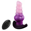 Plug anal fantasia vibratório de silicone em degradê rosa e roxo, ao lado do controle remoto sem fio