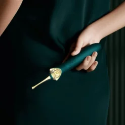 Vibrador de ponta fina verde segurado na mao mostrando o cabo ergonomico