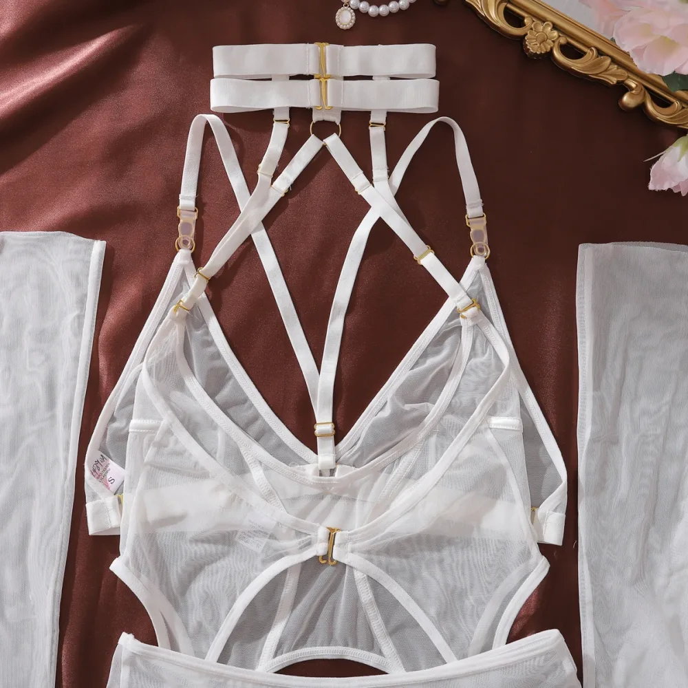 As cinco peças do conjunto Prisioneira: choker, body, calcinha, luvas e meias, dispostas juntas